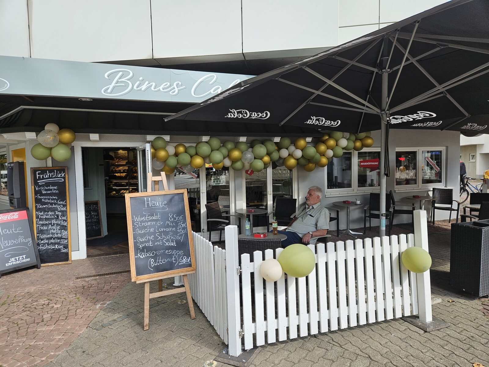 Außenbereich von Bines Café mit Sitzplätzen und Eröffnungsdekoration